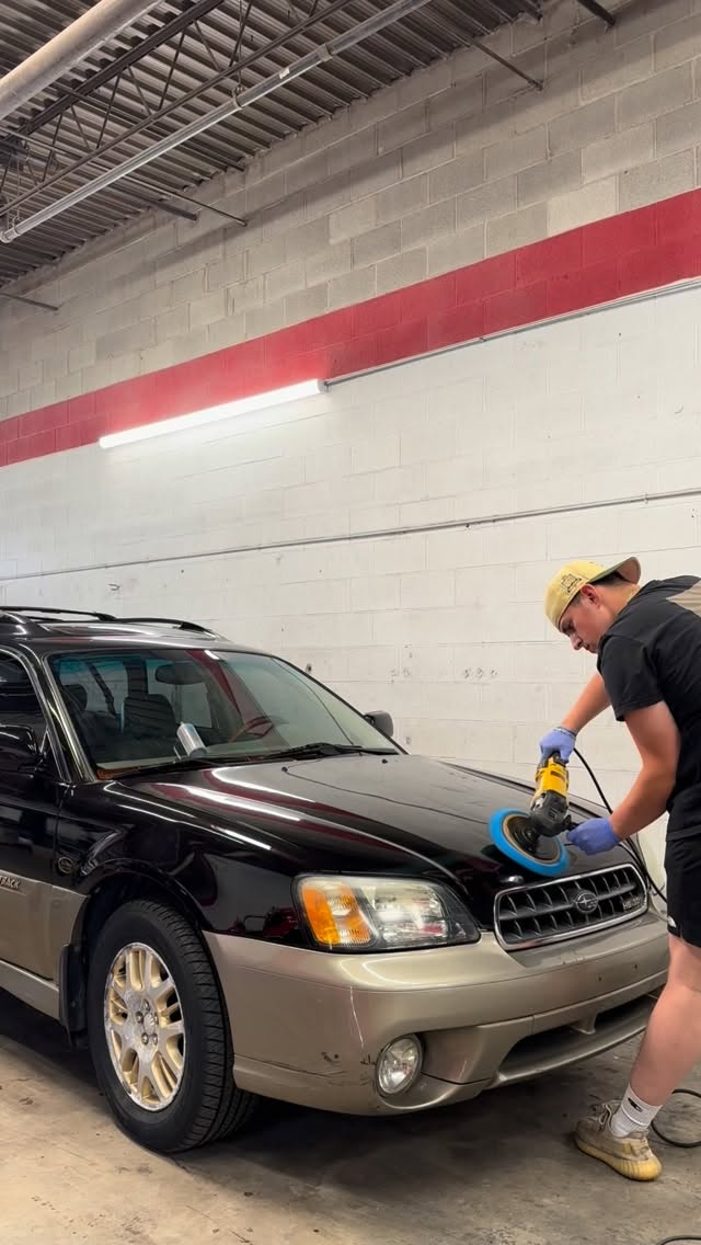 Oscar machine-buffing the hood of a Subaru Outback